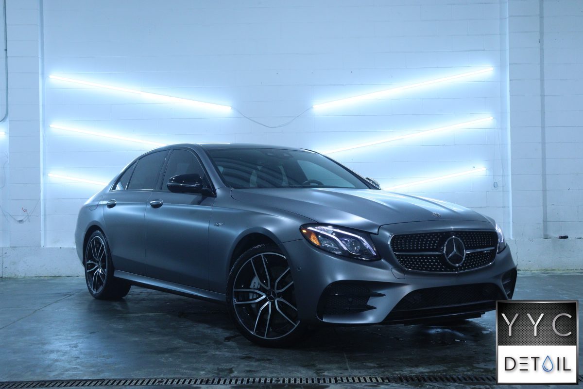 Grey Mercedes sedan side view in a detailing studio